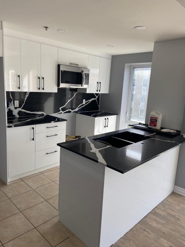 Cuisine blanc laqué avec péninsule en quartz noir veiné