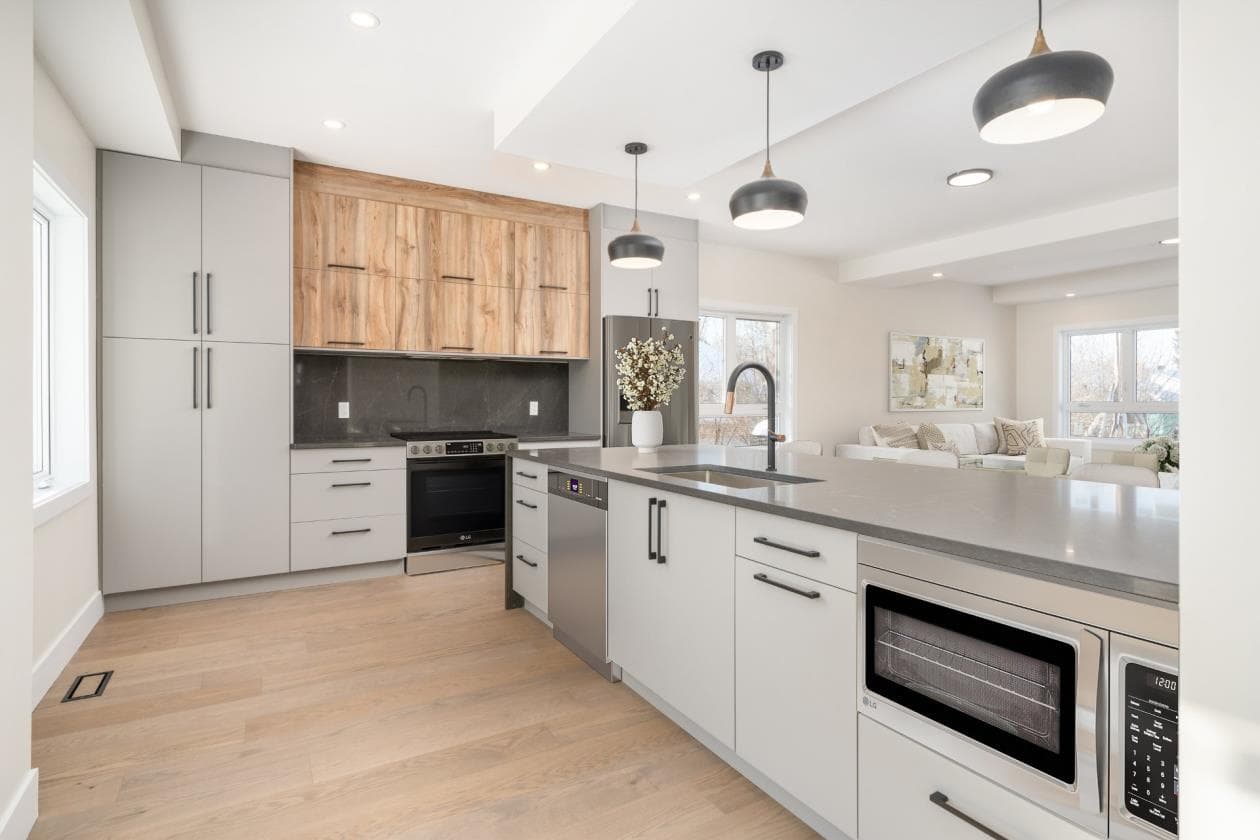 Grey and walnut kitchen with cooking island and black dome pendants