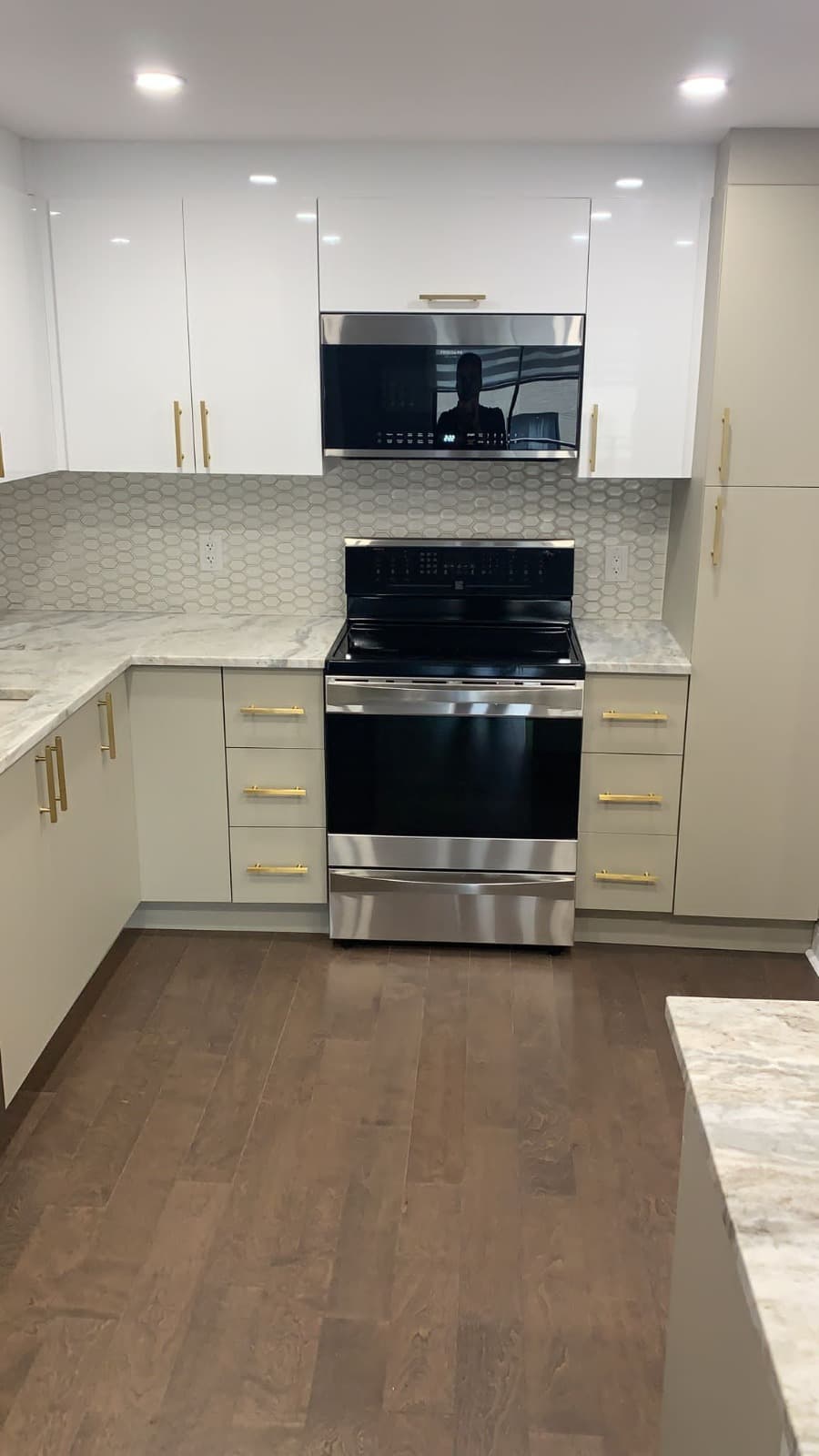 Linen gloss kitchen with hexagon tile backsplash and brass pulls