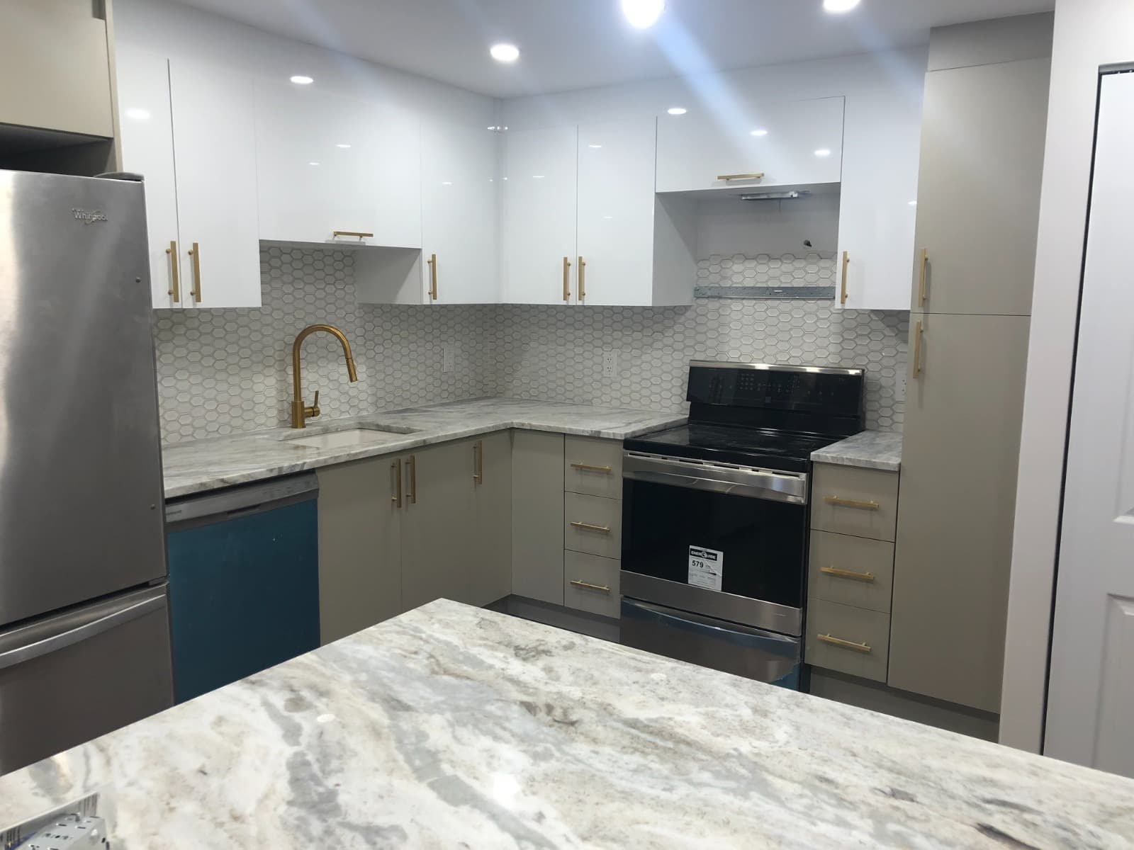 Two-tone linen and white kitchen with hexagon tile and brass faucet