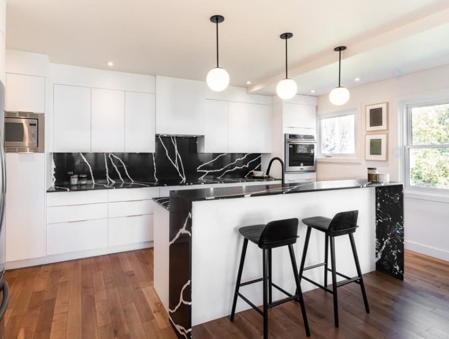 Monochrome kitchen with peninsula and globe pendants