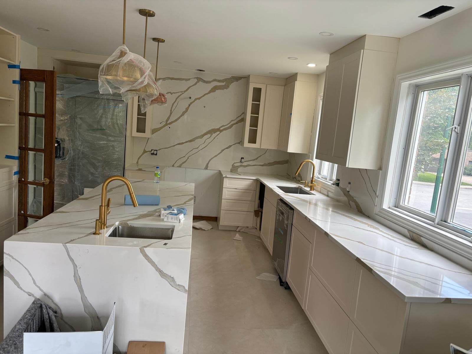 Cuisine transitionnelle avec îlot en quartz calacatta or et robinetterie laiton