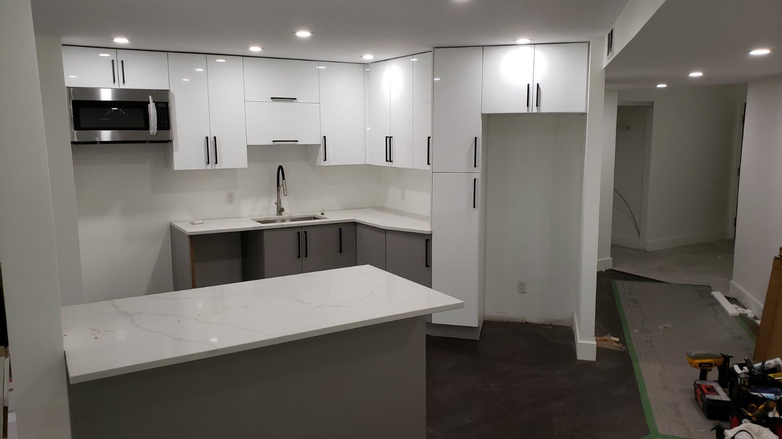 White and grey two-tone kitchen with calacatta quartz peninsula