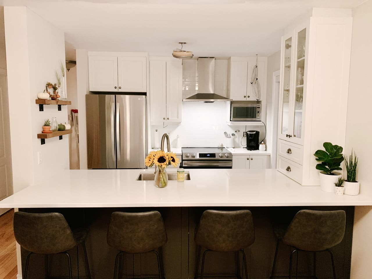 White shaker kitchen with subway tile, open shelving and peninsula