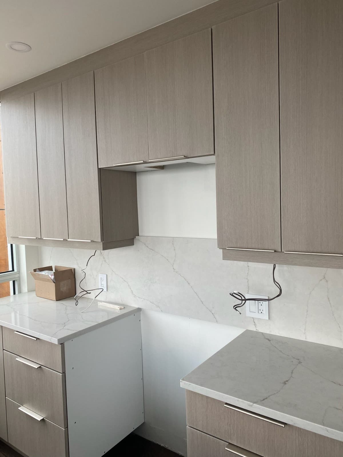 Greige flat-front kitchen with calacatta quartz slab backsplash