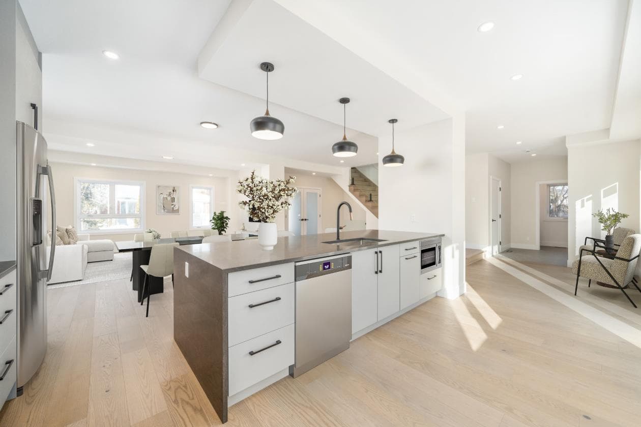 Open-plan white kitchen with concrete quartz island and dome pendants